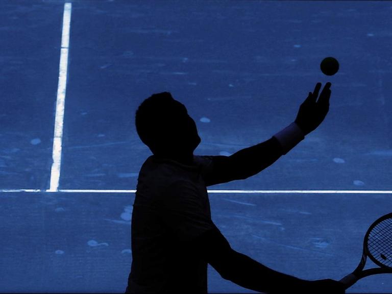 Ein Tennisspieler schlägt vor dem Netz mit der Aufschrift "ATP World Tour" in Madrid auf.