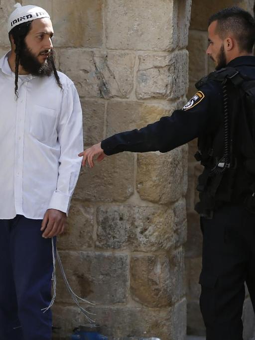 Ein israelischer Sicherheitsmann verweist einen jüdischen Besucher vor die Tür, nachdem dieser in der Al-Aqsa-Moschee ein jüdisches Gebet gesprochen hat, was dort verboten ist.