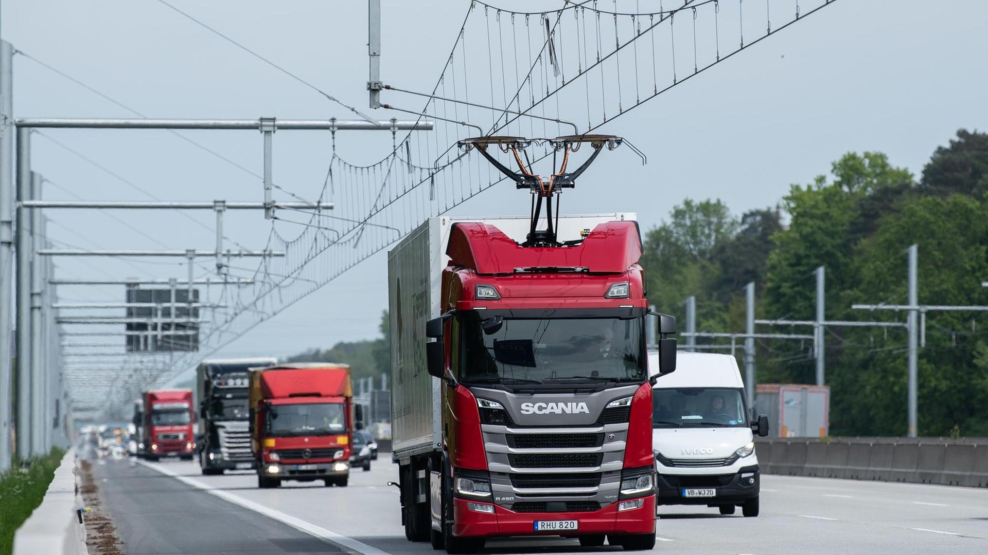 Ein LKW fährt mit ausgefahrenem Stromabnehmer während der Inbetriebnahme der ersten deutschen Teststrecke für E-Lastwagen mit Oberleitung auf der Autobahn 5 (A5).
