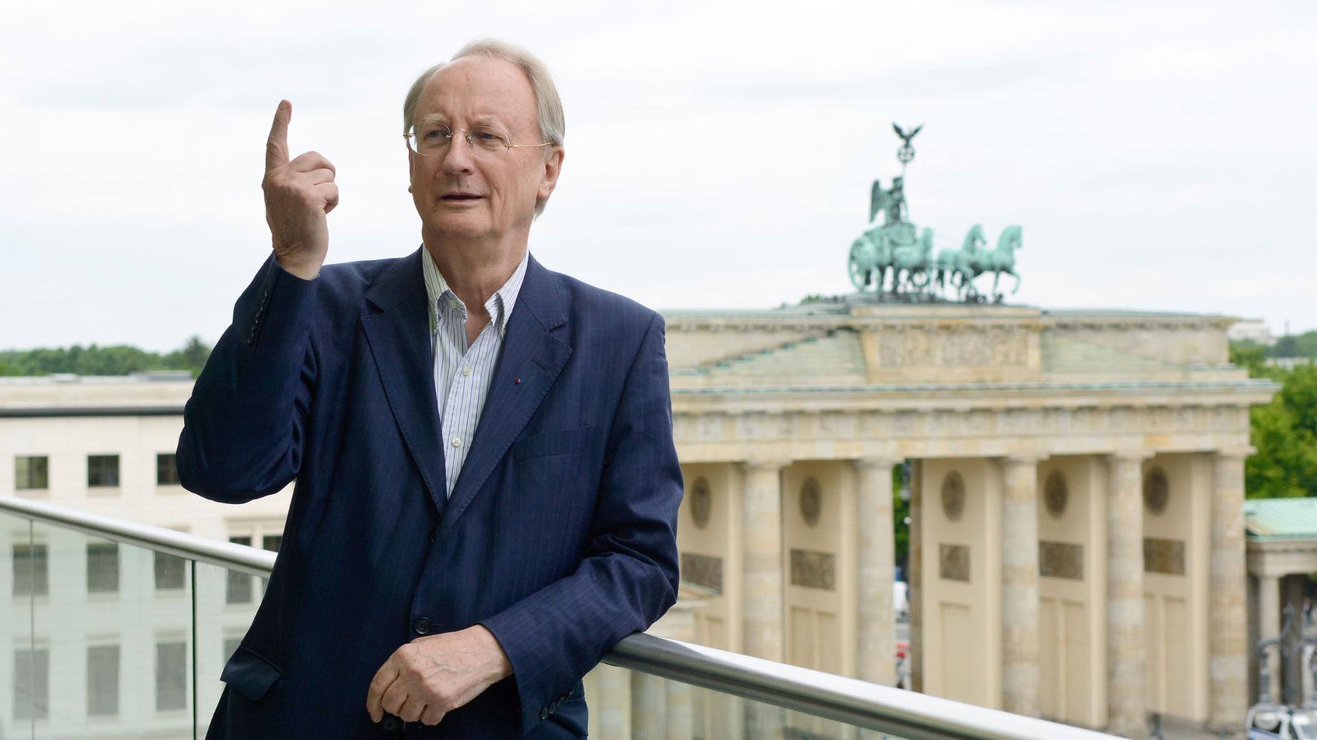 Klaus Staeck, Präsident der Akademie der Künste, steht am 19.05.2015 vor der Kulisse des Brandenburger Tores auf einer Terrasse der Akademie in Berlin. Klaus Staeck gibt nach seiner dritten Amtszeit als Präsident sein Amt ab.