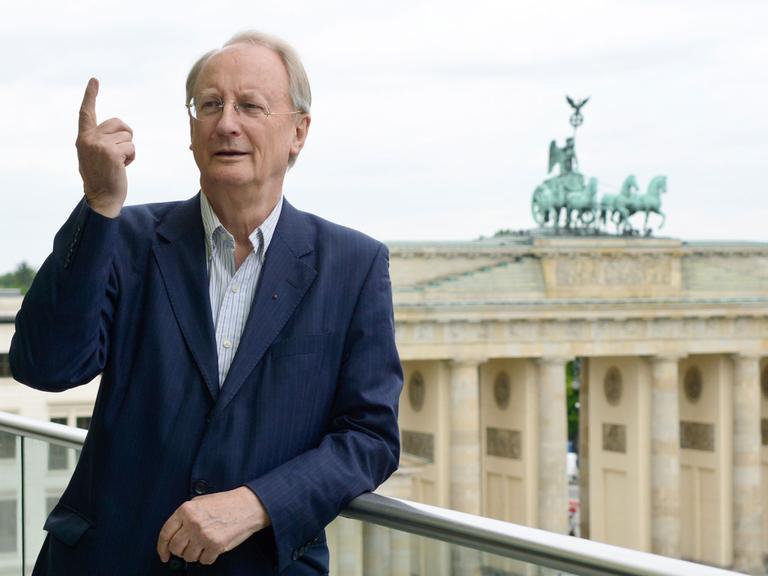Klaus Staeck, Präsident der Akademie der Künste, steht am 19.05.2015 vor der Kulisse des Brandenburger Tores auf einer Terrasse der Akademie in Berlin. Klaus Staeck gibt nach seiner dritten Amtszeit als Präsident sein Amt ab.