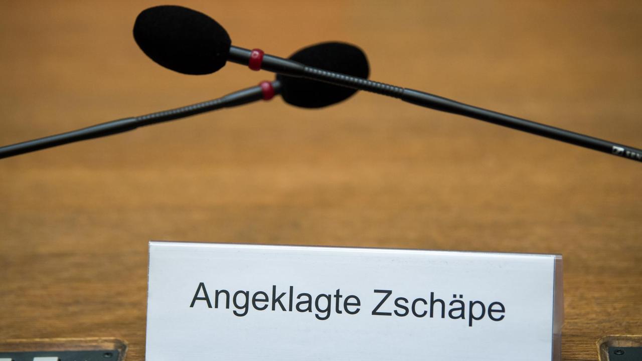 Ein Schild mit der Aufschrift «Angeklagte Zschäpe» steht am 01.09.2017 auf der Anklagebank im Gerichtssaal im Oberlandesgericht in München (Bayern). Mit im Bild: zwei Mikrofone.