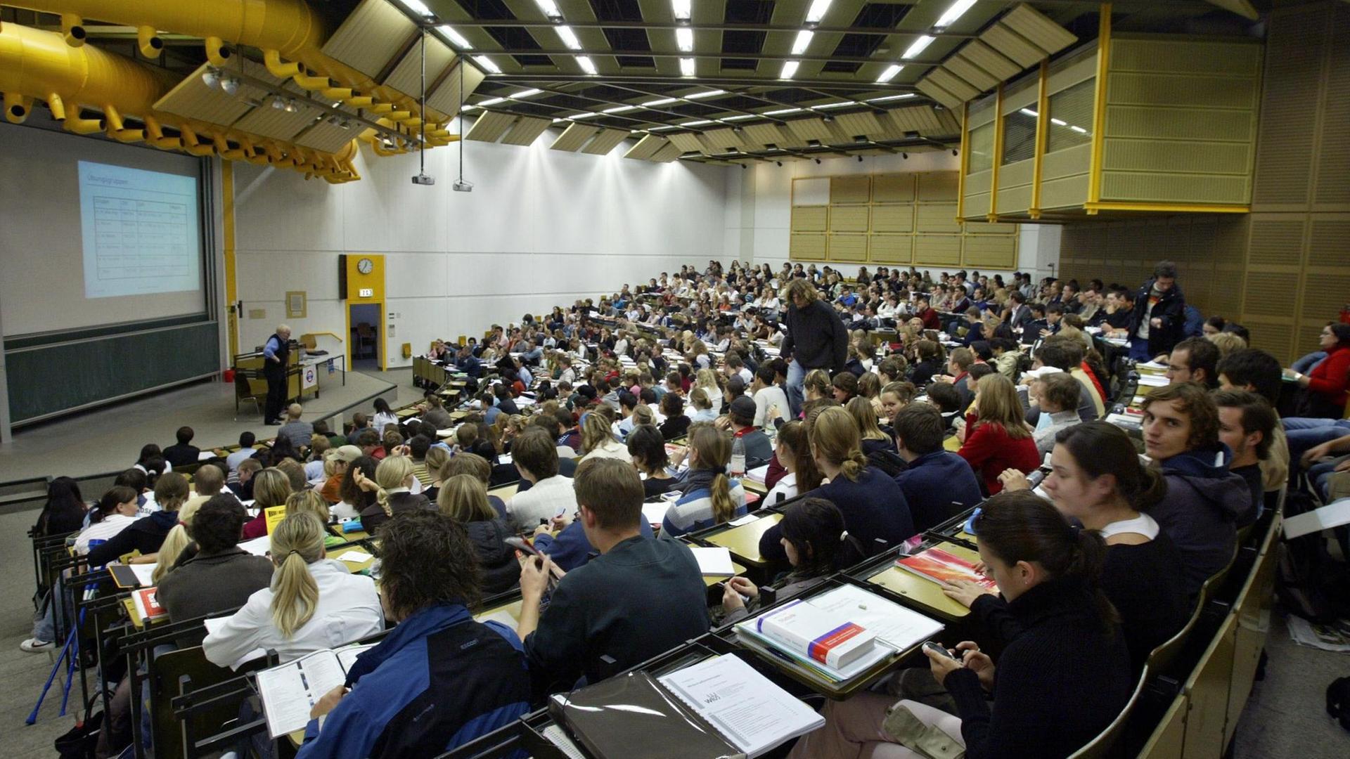 Studenten sitzen während einer Volkswirtschafts-Vorlesung im großen Hörsaal der Universität Augsburg.