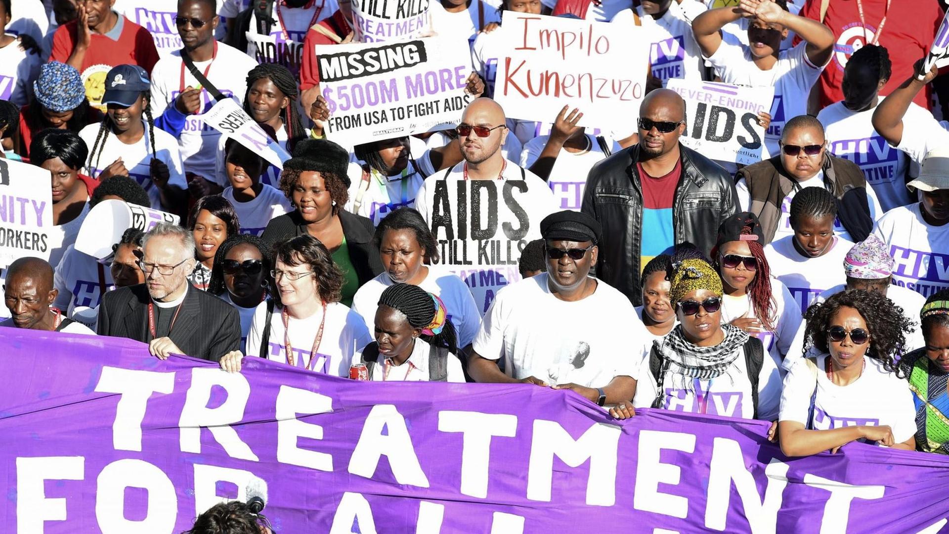 Demonstranten halten in Durban Plakate und Transparente hoch.