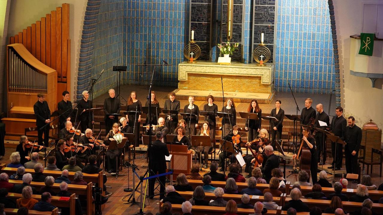 Musiker wie Sänger stehen in der Kirche  der Evangelischen Gemeinde Am Hohenzollernplatz.