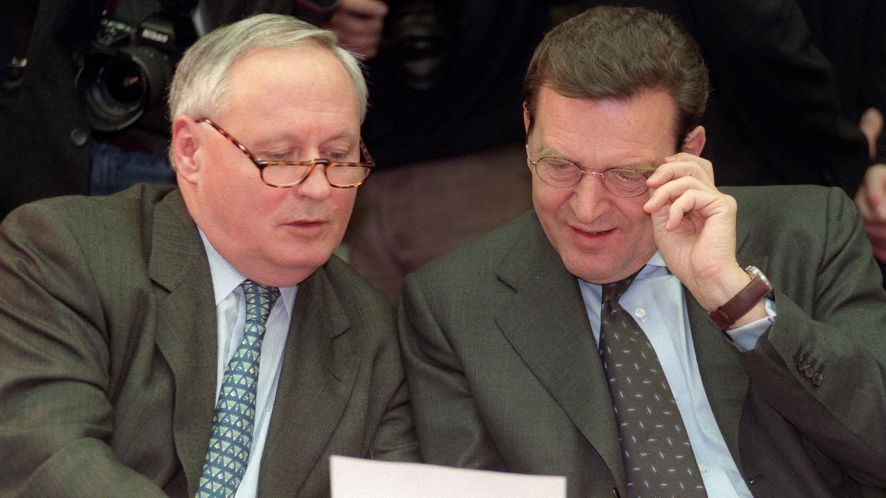 Bundeskanzler Gerhard Schröder (r.) und Finanzminister Oskar Lafontaine wenden sich ihren Unterlagen zu; Aufnahme vom Dezember 1998