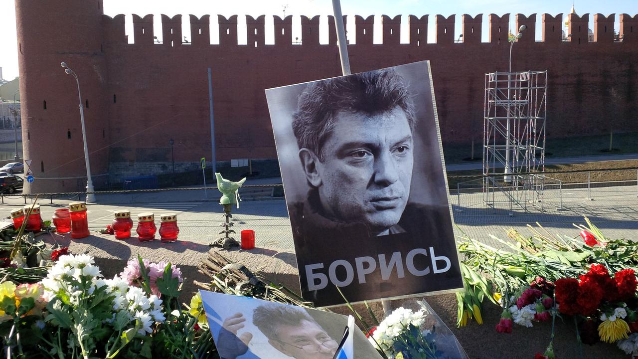 Zwischen den Blumen ist an einem Stock ein schwarz-weiß-Bild Nemzows angebracht.