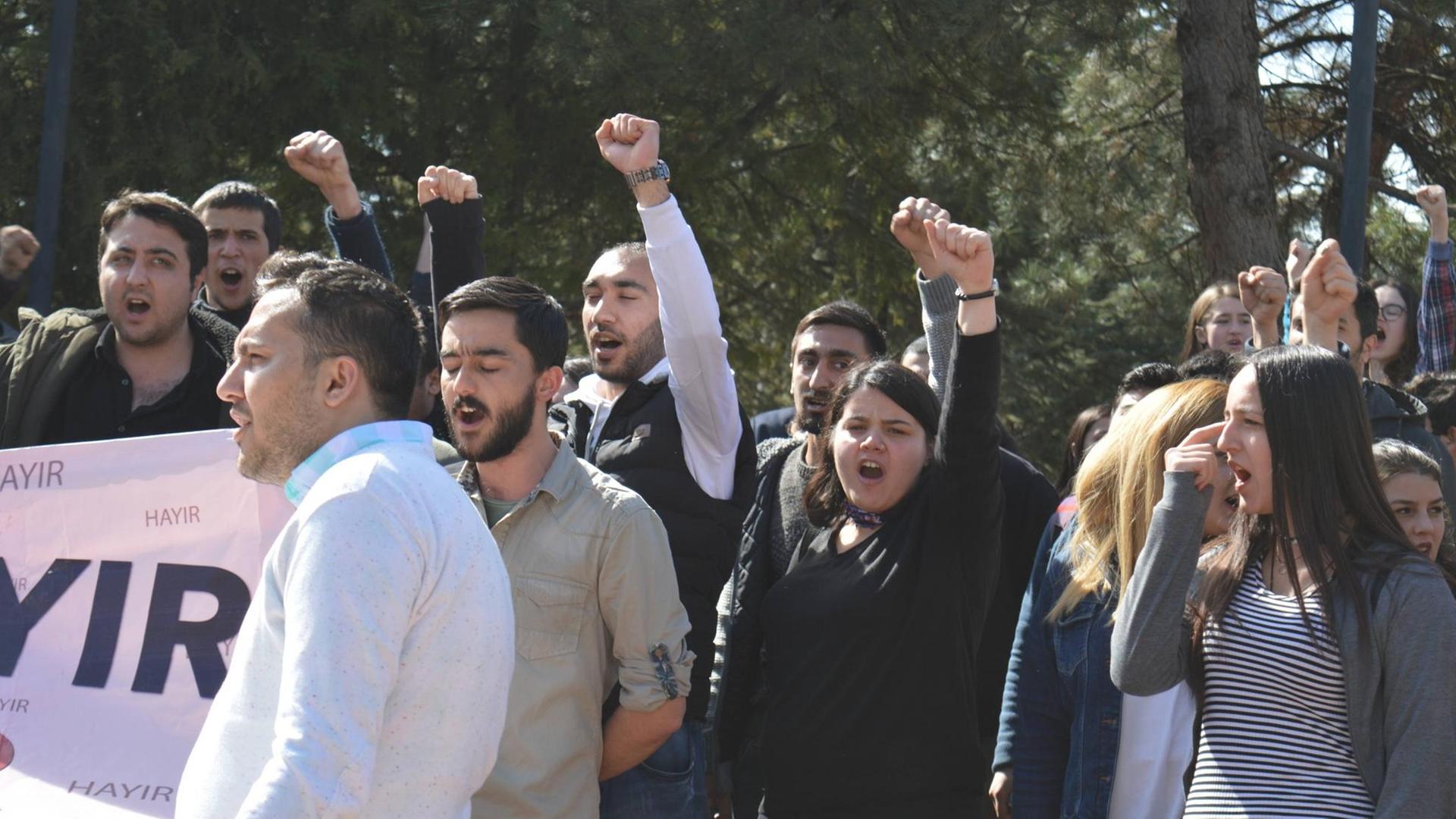 Junge Türken demonstrieren in Ankara gegen eine Verfassungsänderung am 16. April 2017. Junge Männer halten die Fäuste hoch und und halten ein Plakat.