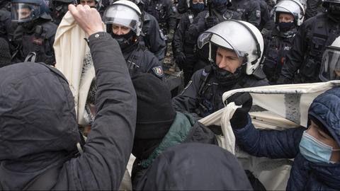 Polizisten drängen an der Hauptwache in Frankfurt am Main Gegendemonstranten weg, die sich einer eigentlich gerichtlich verbotenen "Querdenker"-Demo in den Weg gestellt hatten.