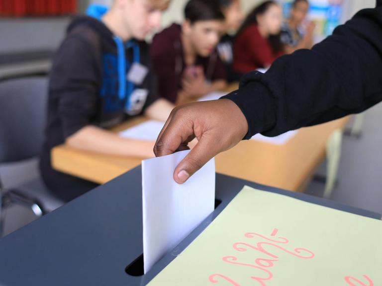 Ein minderjähriger Schüler an der Wahlurne in der Schule, bei der U18-Wahl zum Deutschen Bundestag.