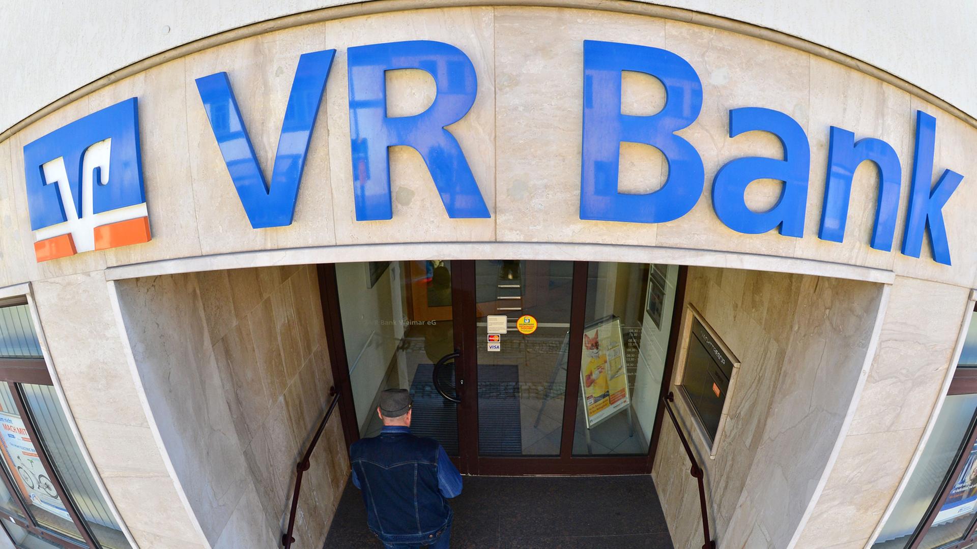 Ein Mann betritt eine Filiale der VR Bank Weimar eG.