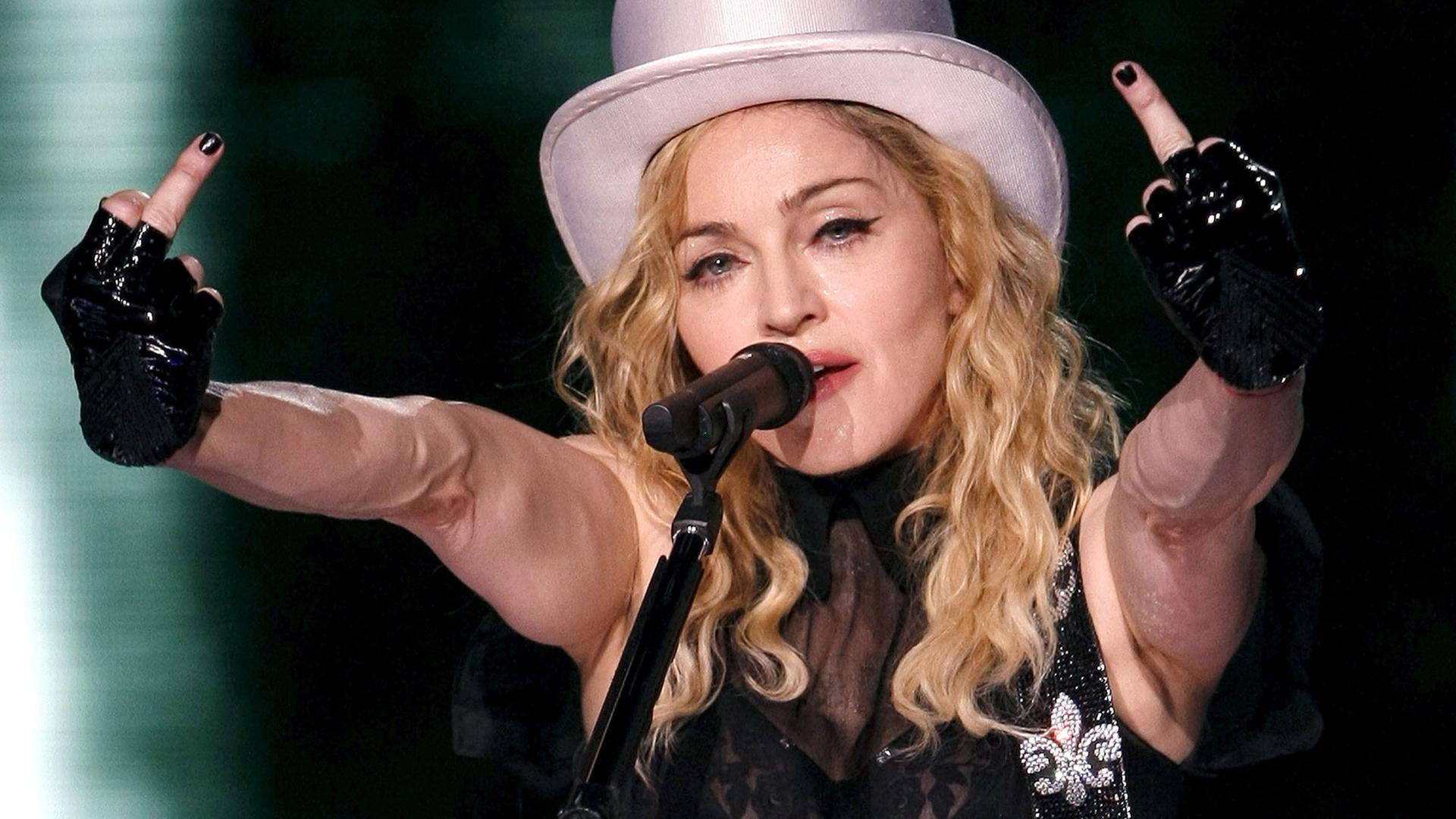 Die US-Sängerin Madonna reckt bei einem Auftritt während ihrer "Sticky and Sweet Tour" im Juli 2009 in Madrid beide Mittelfinger in die Höhe.