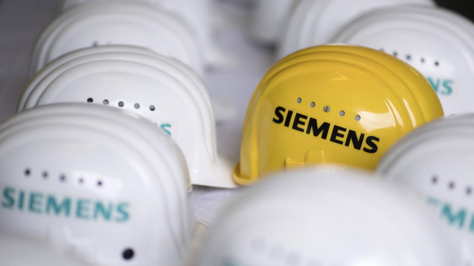 Logo der Siemens AG auf einem gelben Schutzhelm im Siemens-Gasturbinenwerk bei der Siemens AG in der Turbinenhalle in Berlin.