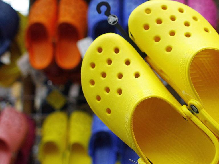 Ein Paar gelbe Kunststoffschuhe, die als "Crocs" – benannt nach einem amerikanischen Unternehmen - bekannt wurden