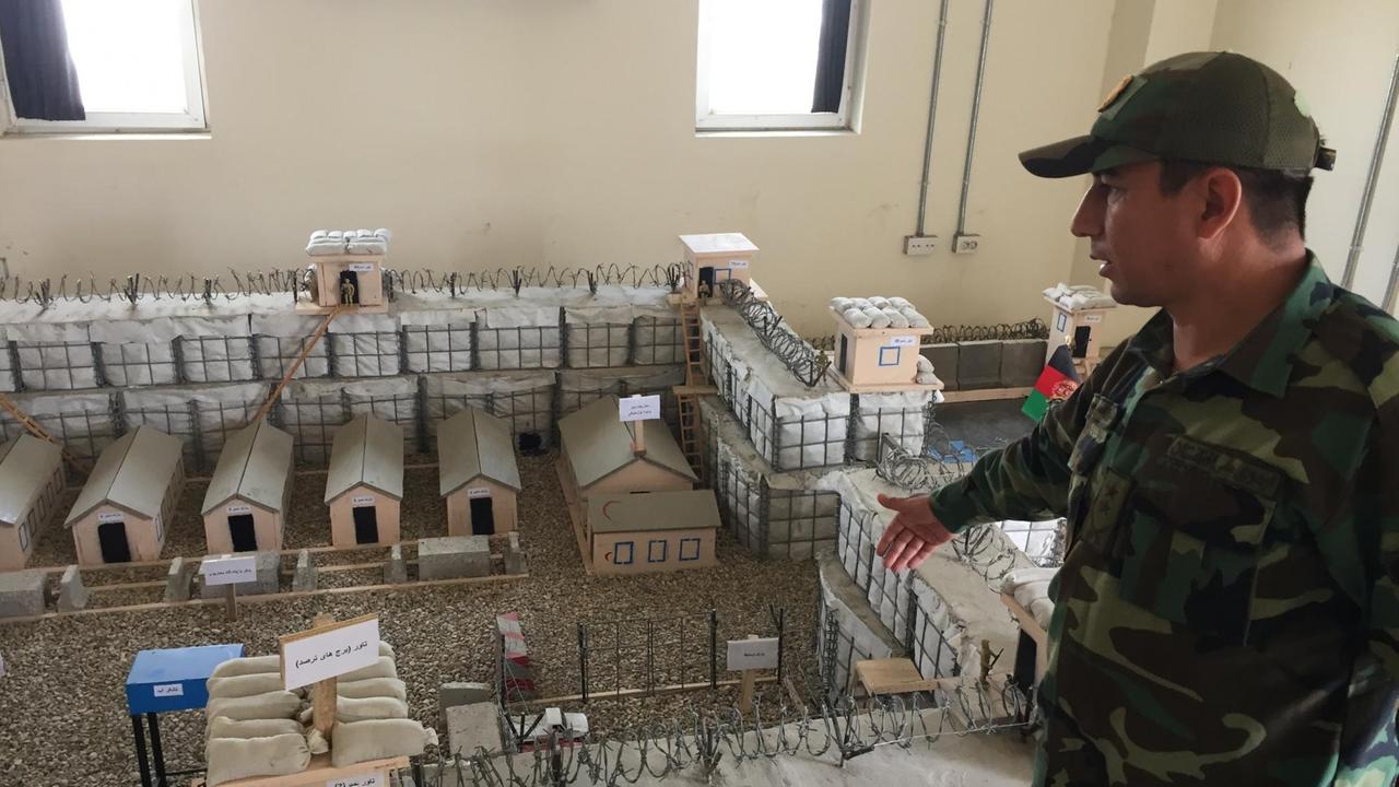 Ein Oberst der afghanischen Streitkräfte zeigt auf ein Sandkastenmodell.