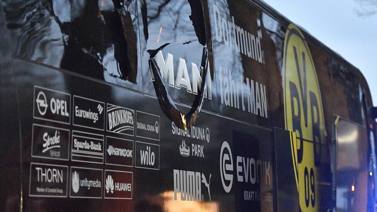 Ein Seitenfenster des schwarz-gelben Busses mit dem BVB-Logo ist zerstört.