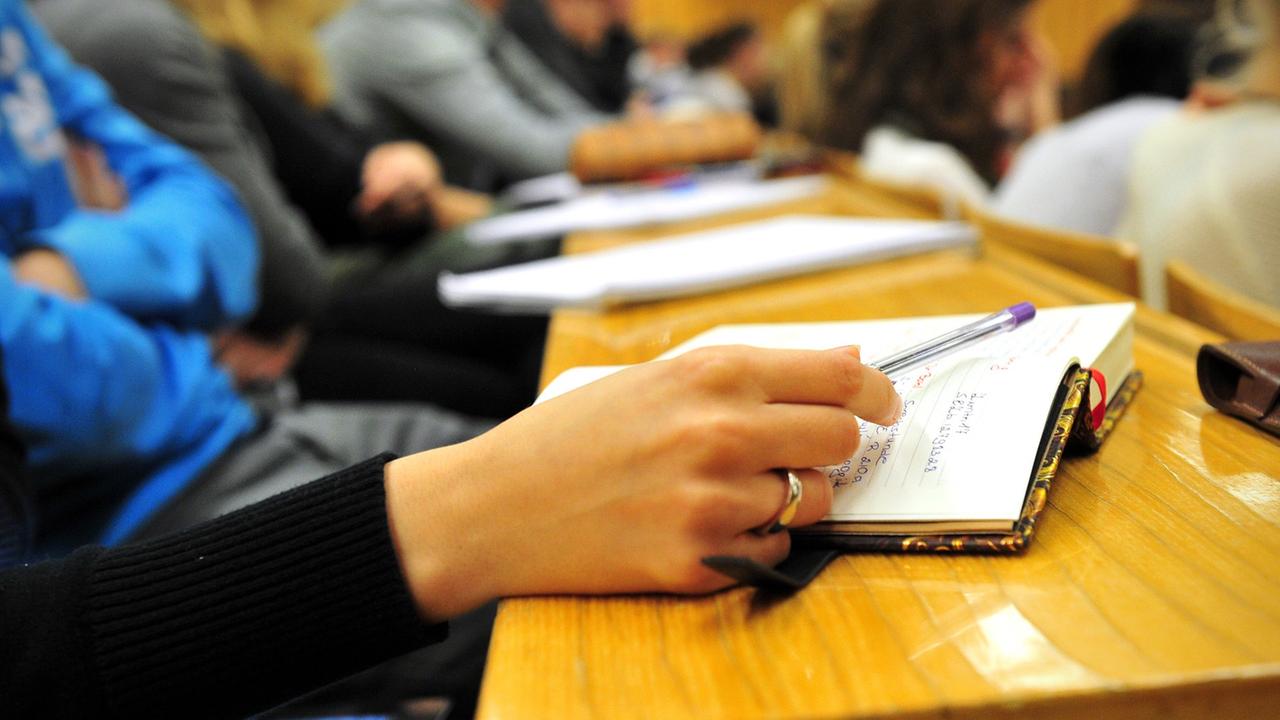 Eine Studentin der Schulpädagogik schreibt am 17.10.2012 während einer Vorlesung in einem vollen Hörsaal in der Universität in Tübingen (Baden-Württemberg) mit.