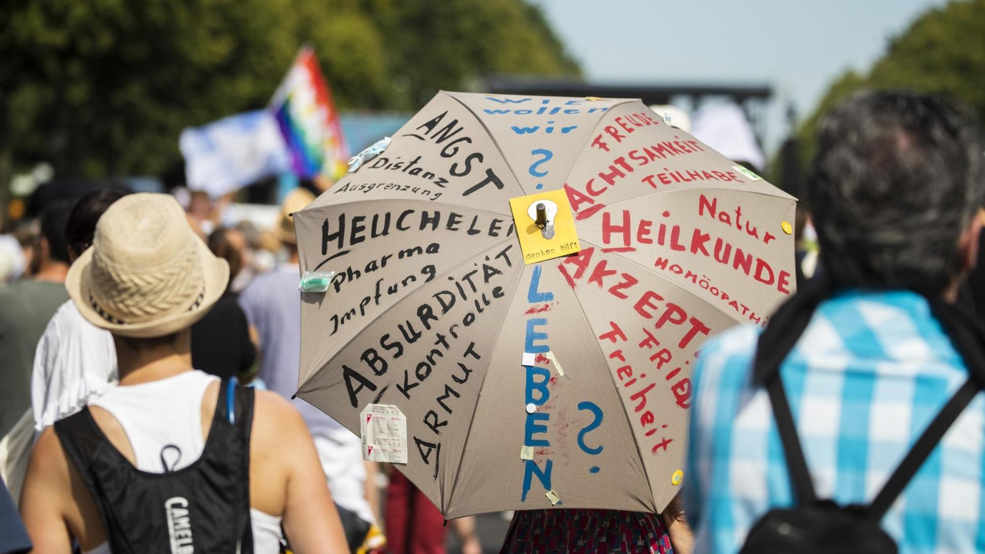 Anti-Corona-Demonstration in Berlin. Auf einem Schirm steht u. a.: "Wie wollen wir leben?"