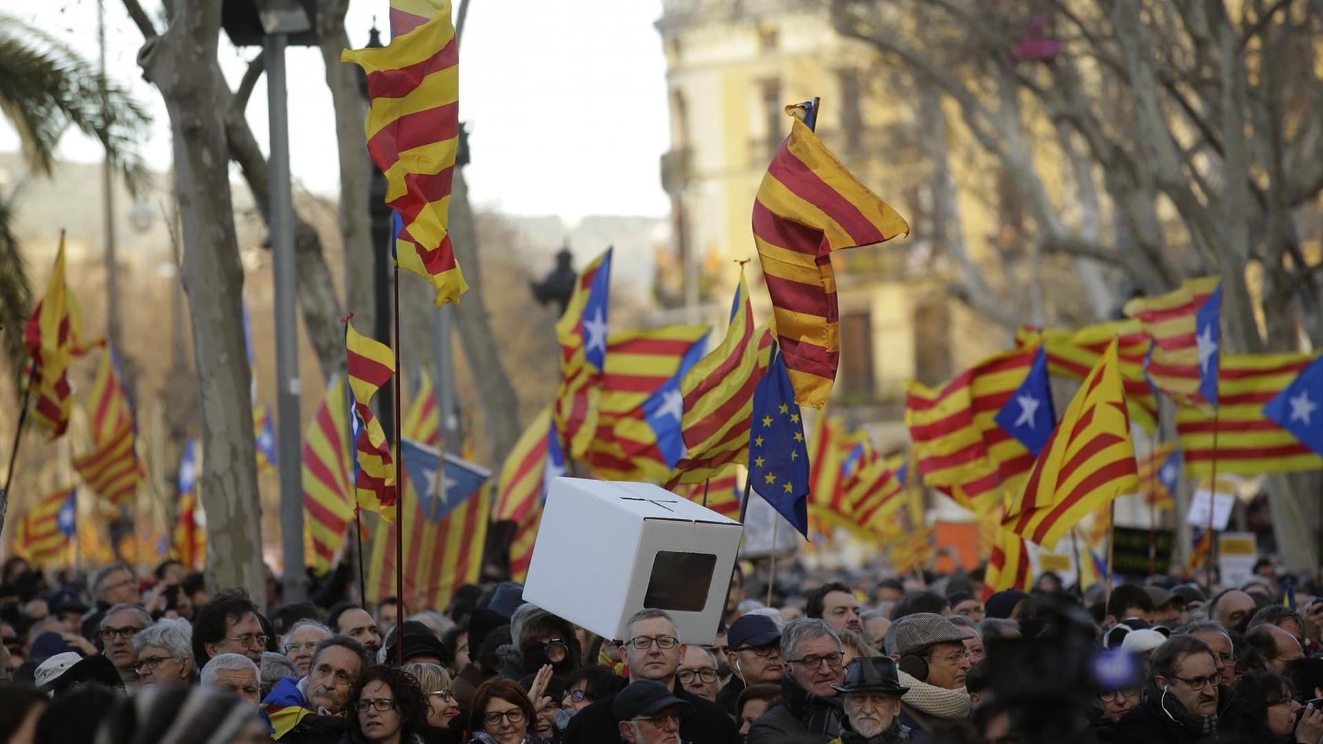 Menschen halten "estelada" oder Pro-Unabhängigkeits-Fahnen hoch, nachdem der frühere Präsident der katalanischen Regionalregierung am 6. Februar 2017 bei Gericht in Barcelona/Spanien eintrifft. Tausende gehen aus Protest gegen das Verfahren gegen drei katalanische Politiker auf die Straße.