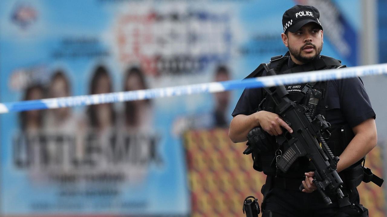 Ein bewaffneter Polizist steht nach dem Anschlag in Manchester nahe des Tatorts.
Ein bewaffneter Polizist steht nach dem Anschlag in Manchester nahe des Tatorts.
