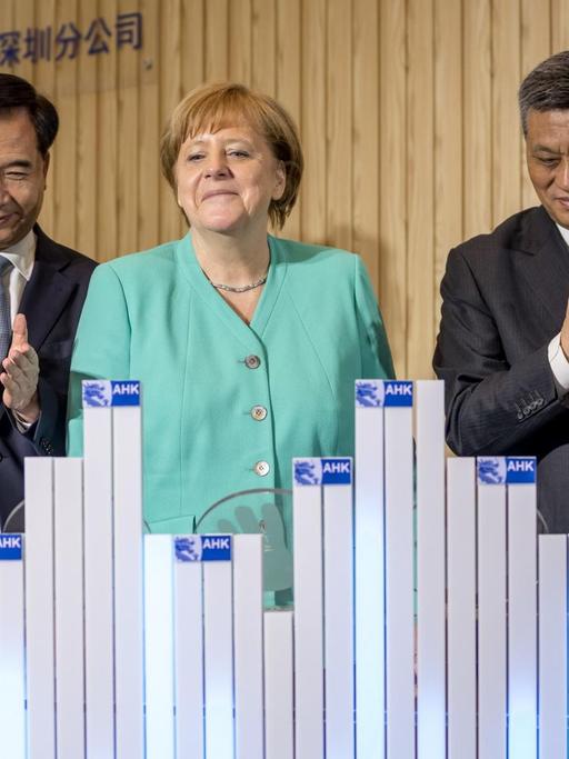 Bundeskanzlerin Angela Merkel (CDU) steht neben Staatssekretär Ulrich Nussbaum (l-r), Li Xi, Parteisekretär der Provinz Guangdong, Provinzgouverneur Ma Xingru und dem Außenhandelskammer Beauftragter Jens Hildebrand, bei der Eröffnung des AHK-Innovation Hub Shenzhen.