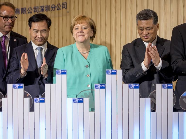 Bundeskanzlerin Angela Merkel (CDU) steht neben Staatssekretär Ulrich Nussbaum (l-r), Li Xi, Parteisekretär der Provinz Guangdong, Provinzgouverneur Ma Xingru und dem Außenhandelskammer Beauftragter Jens Hildebrand, bei der Eröffnung des AHK-Innovation Hub Shenzhen.