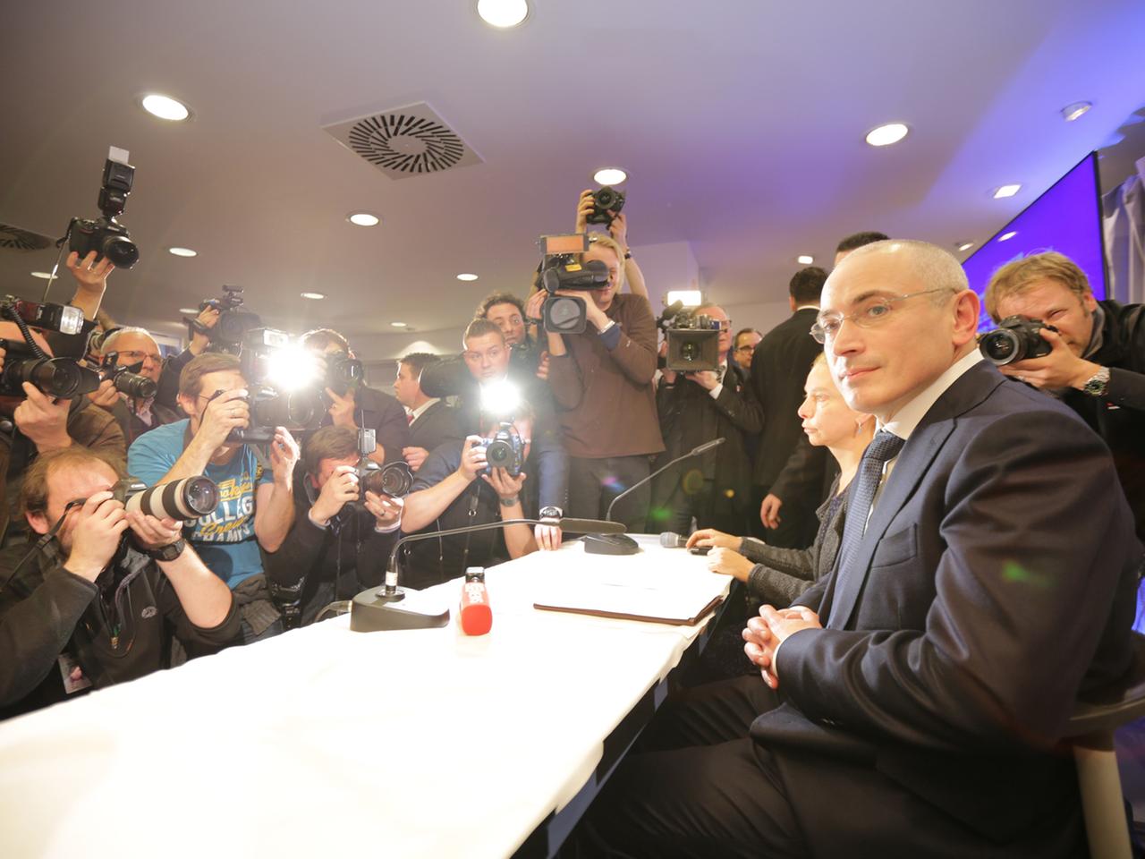 Der russische Kreml-Kritiker Michail Chodorkowski (r.) sitzt am 22.12.2013 im «Mauermuseum am Checkpoint Charlie» in Berlin bei einer Pressekonferenz. Foto: Michael Kappeler/dpa