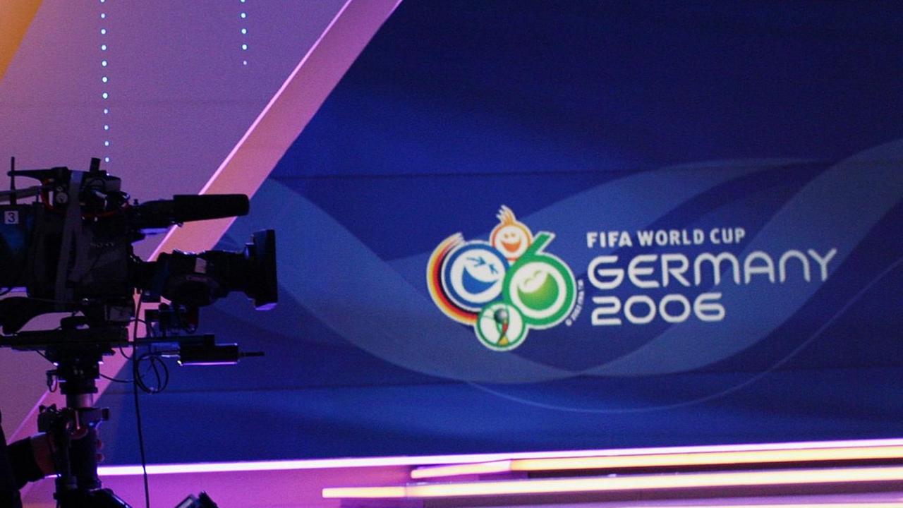 Eine Kamera steht vor einer Bühne mit dem Logo der Fußball-WM 2006.