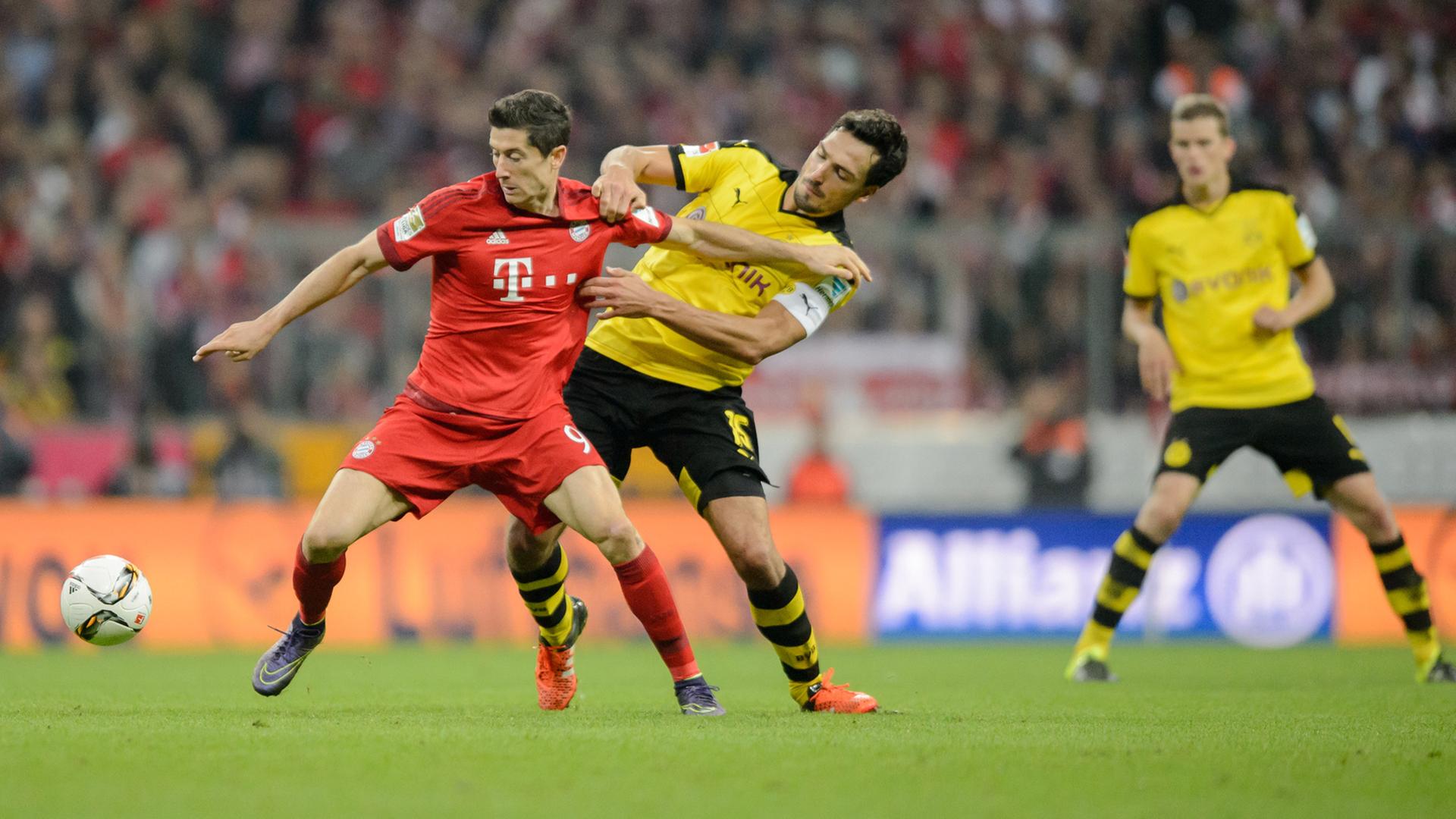 Robert Lewandowski (rot), Fußball-Bundesliga-Spieler von Bayern München, gegen Mats Hummels von Borussia Dortmund