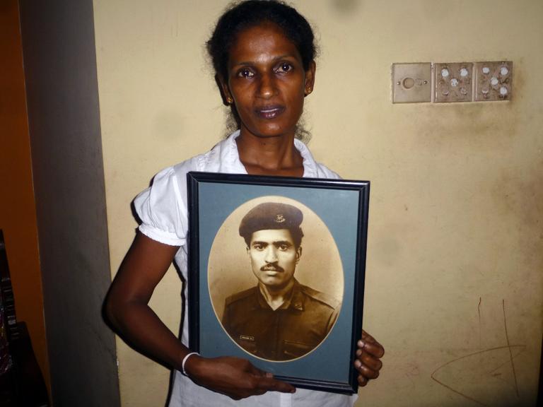Kriegswitwe Wimala mit einem Bild ihres Mannes in der Hand.