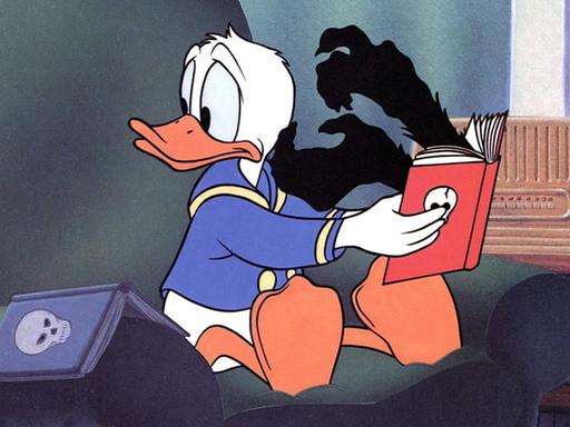 Donald Duck liest in einem Buch, aus dem ihm schwarze Hände entgegenkommen.