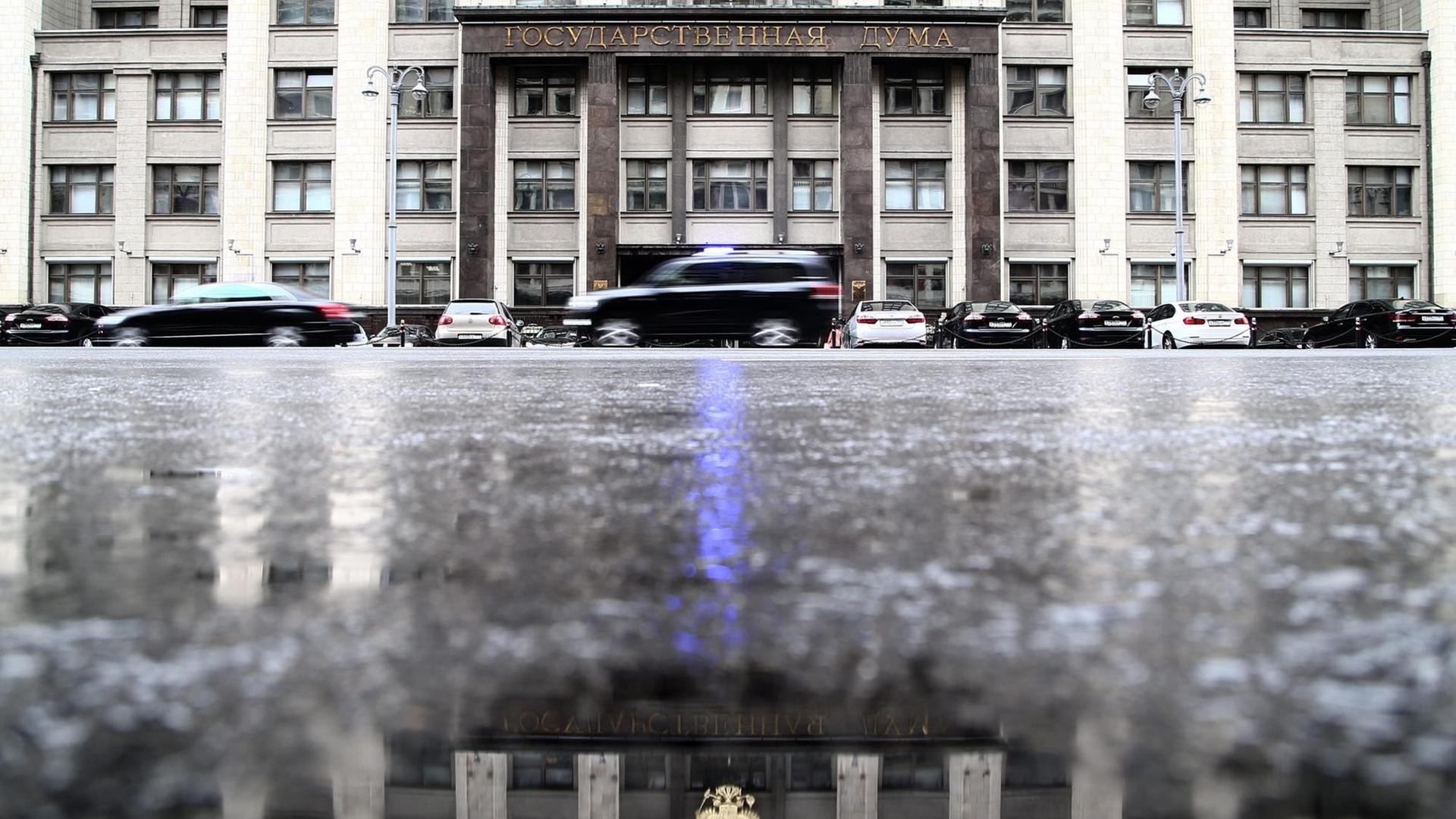 Das Blaulicht eines Regierungsfahrzeug spiegelt sich auf dem Boden vor dem Duma-Gebäude in der russischen Hauptstadt Moskau.