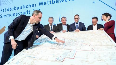 08.01.2020, Berlin: Cedrik Neike (l-r), Mitglied des Vorstands der Siemens AG, Helmut Kleebank (SPD), Bezirksbürgermeister von Spandau, Stefan Behnisch, Architekt, Michael Müller (SPD), Berlins Regierender Bürgermeister und Ramona Pop (Bündnis 90/Die Grünen), Wirtschaftssenatorin, sehen sich den Entwurf für Siemensstadt 2.0 an. Foto: Britta Pedersen/dpa-Zentralbild/dpa | Verwendung weltweit