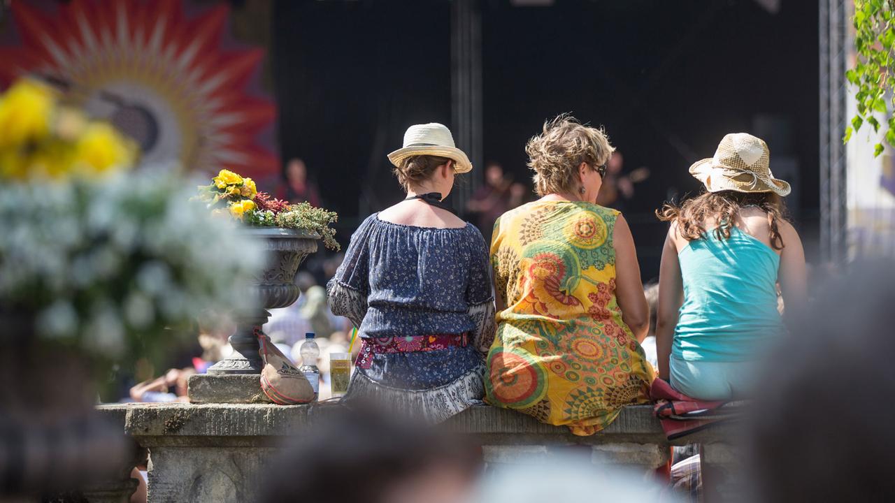 Besucher verfolgen das Programm beim Folk-Festival in Rudolstadt auf der Heidecksburg.