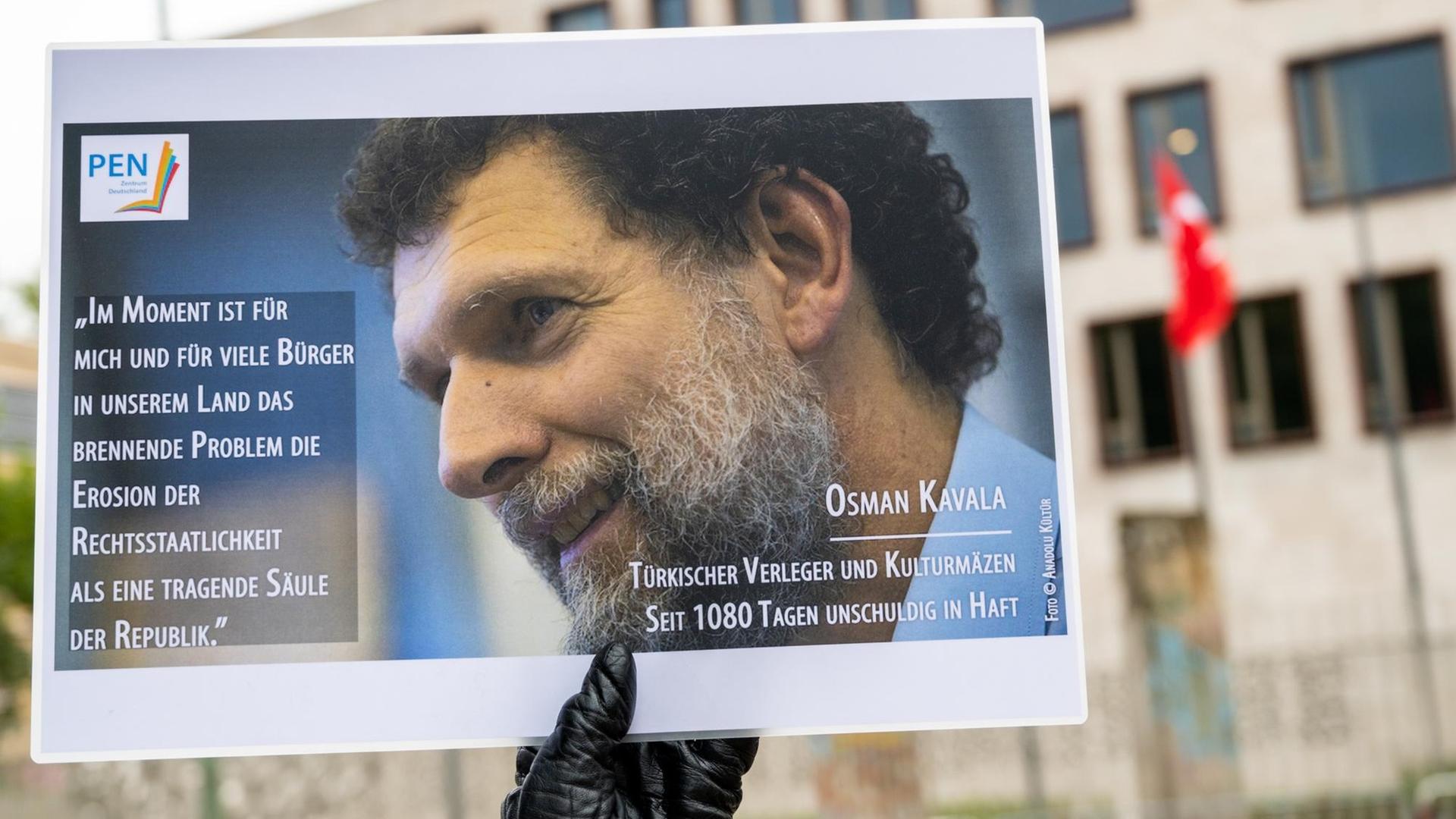 Ein Mann hält bei einer Mahnwache des PEN-Zentrums für den türkischen Verleger und Kulturmäzen Osman Kavala vor der Türkischen Botschaft ein Bild von Kavala. Foto: dpa