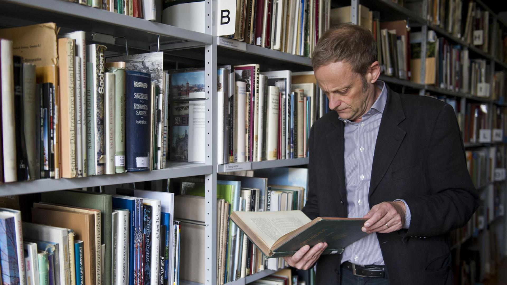 Der Leiter der Provenienzforschung, Gilbert Lupfer, schaut am 13.08.2013 in der Bibliothek der Staatlichen Kunstsammlung im Residenzschloss in Dresden (Sachsen) in ein Buch.