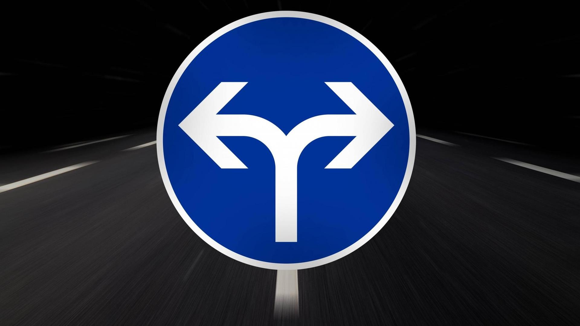 Ein blaues rundes Verkehrsschild mit einem weißen Pfeil, der nach links zeigt, und einem Pfeil, der nach rechts zeigt.