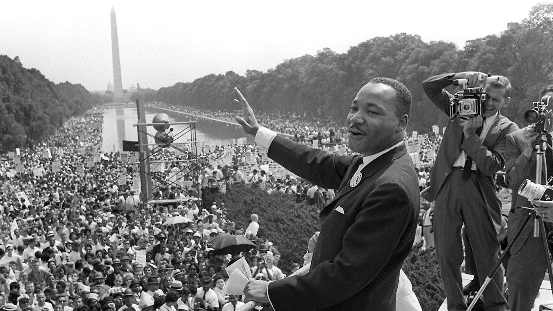 Martin Luther King am 28. August 1963 in Washington, D. C. winkt den Demonstranten zu.