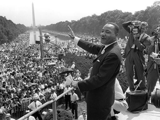 Martin Luther King am 28. August 1963 in Washington, D. C. winkt den Demonstranten zu.