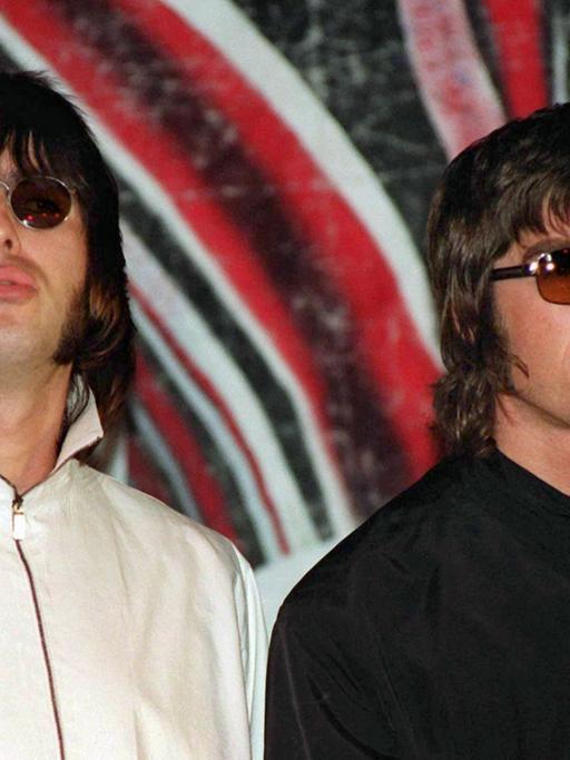 Liam (l.) und Noel Gallagher von der britischen Rockband Oasis bei einer Pressekonferenz 1999 in London.