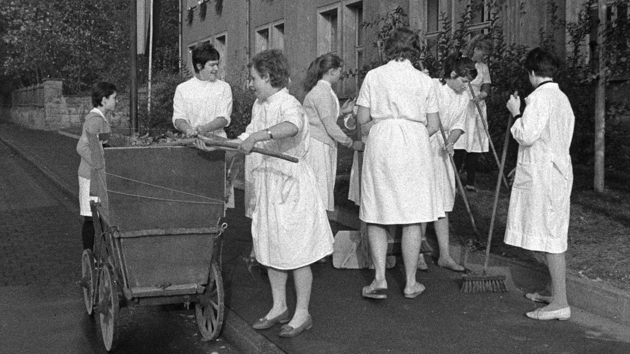 Großsaubermachen in Jena - medizinische Angestellte säubern den Gehweg vor dem Besuch des polnischen PVAP-Chefs Gomulka, aufgenommen am 17.10.1962.