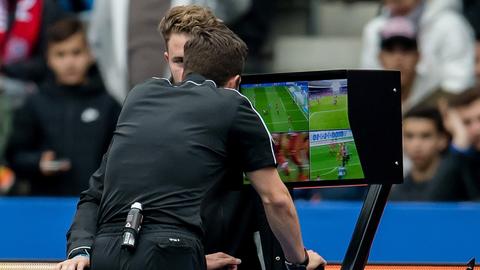 Schiedsrichter Harm Osmers zeigt den Videobeweis an und überprüft eine Elfmeter-Szene am Monitor.