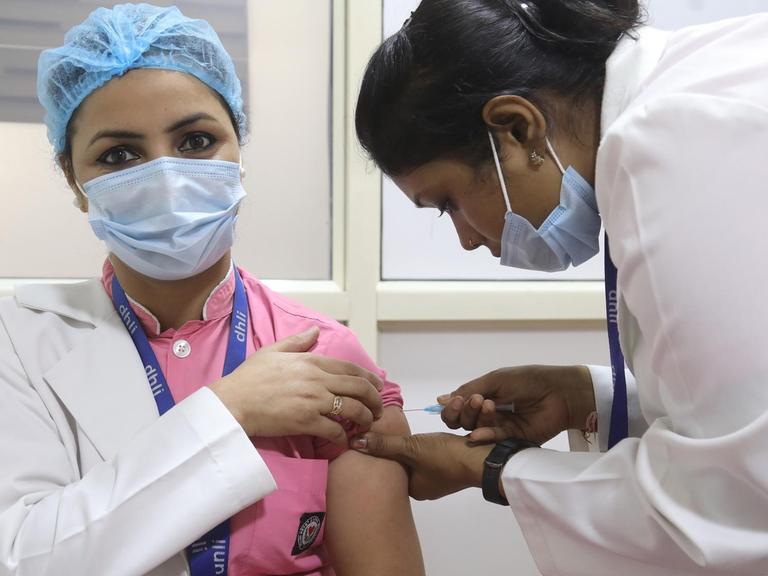 Im indischen Neu-Delhi erhält eine Mitarbeiterin des Gesundheitswesens ihre erste Impfung gegen Corona mit Covaxin.