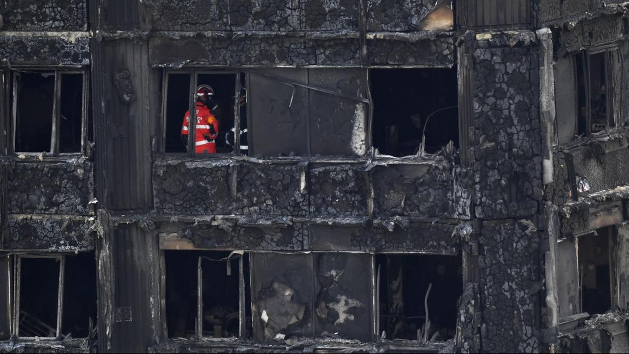 Feuerwehrmänner und Ermittler in dem ausgebrannten Grenfell Tower in London.
