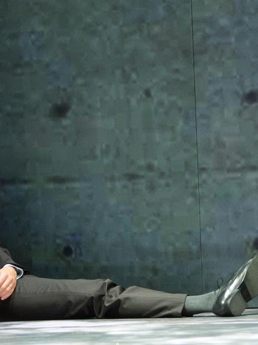 Der Schauspieler Timo Weisschnur sitzt bei einer Fotoprobe zum Stück "Terror" von Ferdinand von Schirach im Deutschen Theater in Berlin auf der Bühne