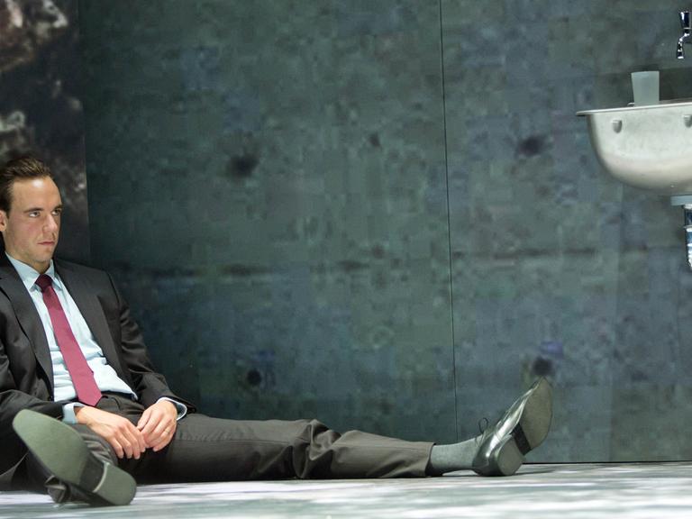Der Schauspieler Timo Weisschnur (Lars Koch, Pilot eines Kampfjets der Bundeswehr) sitzt bei einer Fotoprobe zum Stück "Terror" von Ferdinand von Schirach im Deutschen Theater in Berlin auf der Bühne.