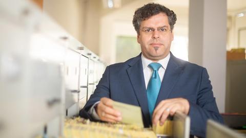 Jens Rommel, Leiter der Zentralen Stelle zur Aufklärung von NS-Verbrechen, blättert in Akten