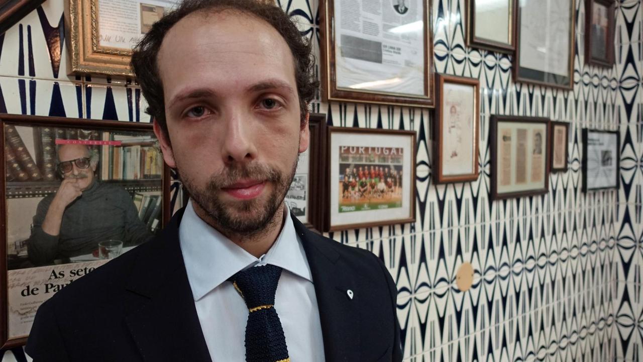Der konservative Kolumnist João Esteves Lemos vor einer Wand  imt Politikerfotos in einem Restaurant in Lissabon