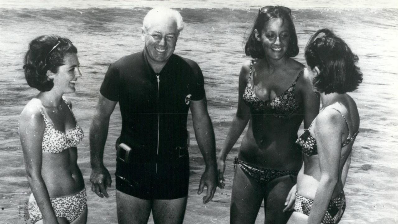 Schwarz-Weiß-Aufnahme des früheren australischen Premierministers Harold Holt mit seinen Schwiegertöchtern am Strand von Portsea.