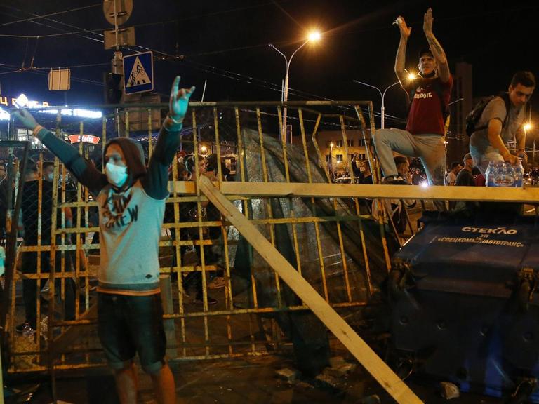 Anhänger der Opposition stehen in Minsk nachts vor und auf einer errichteten Barrikade und demonstrieren gegen das Ergebnis der Präsidentschaftswahl in Belarus.